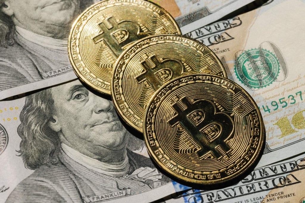 Monety Bitcoin leżące na dolarach jako symbol opłat za inwestowanie w kryptowaluty
